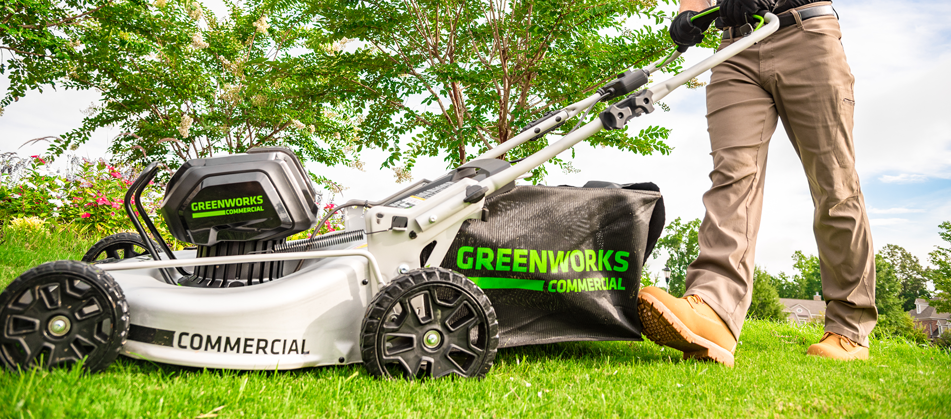 Man using electric push mower in brown workboots